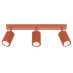 Lampa sufitowa Karbon w kolorze ochra czerwona, z trzema punktami świetlnymi GU10. Każdy spot ma teksturowaną obudowę z rowkami i okrągłą, białą osłoną. Produkt zamontowany na prostokątnej, płaskiej podstawie.