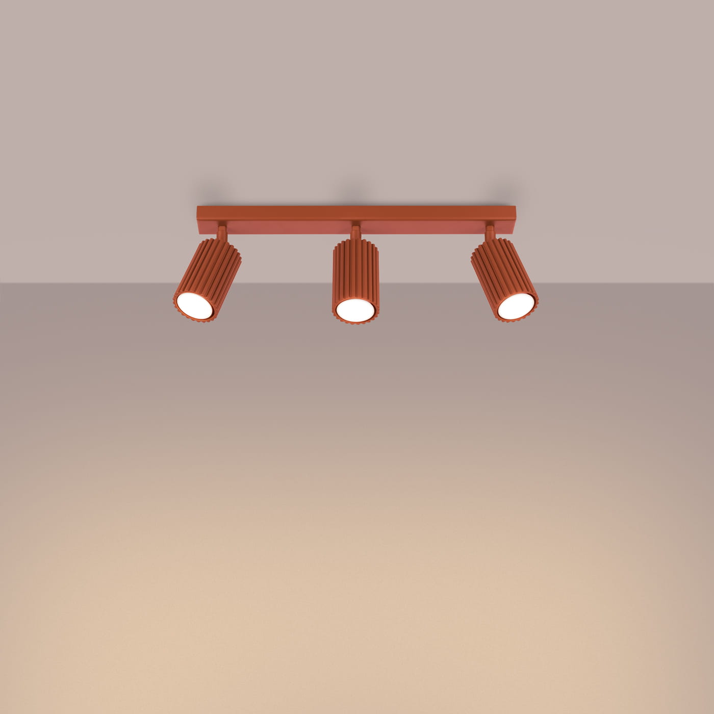 Lampa sufitowa Karbon w kolorze ochra, z trzema reflektorami GU10. Reflektory mają teksturowaną, cylindryczną formę, zamontowane na prostokątnej podstawie. Ujęcie frontalne, produkt wisi na suficie, na jednolitym tle.