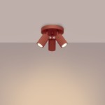 Lampa sufitowa Karbon w kolorze ochra czerwona z trzema reflektorami GU10. Ujęcie z góry, pokazujące okrągłą podstawę oraz żłobione klosze skierowane w różne kierunki. Produkt zamontowany na jasnym tle.