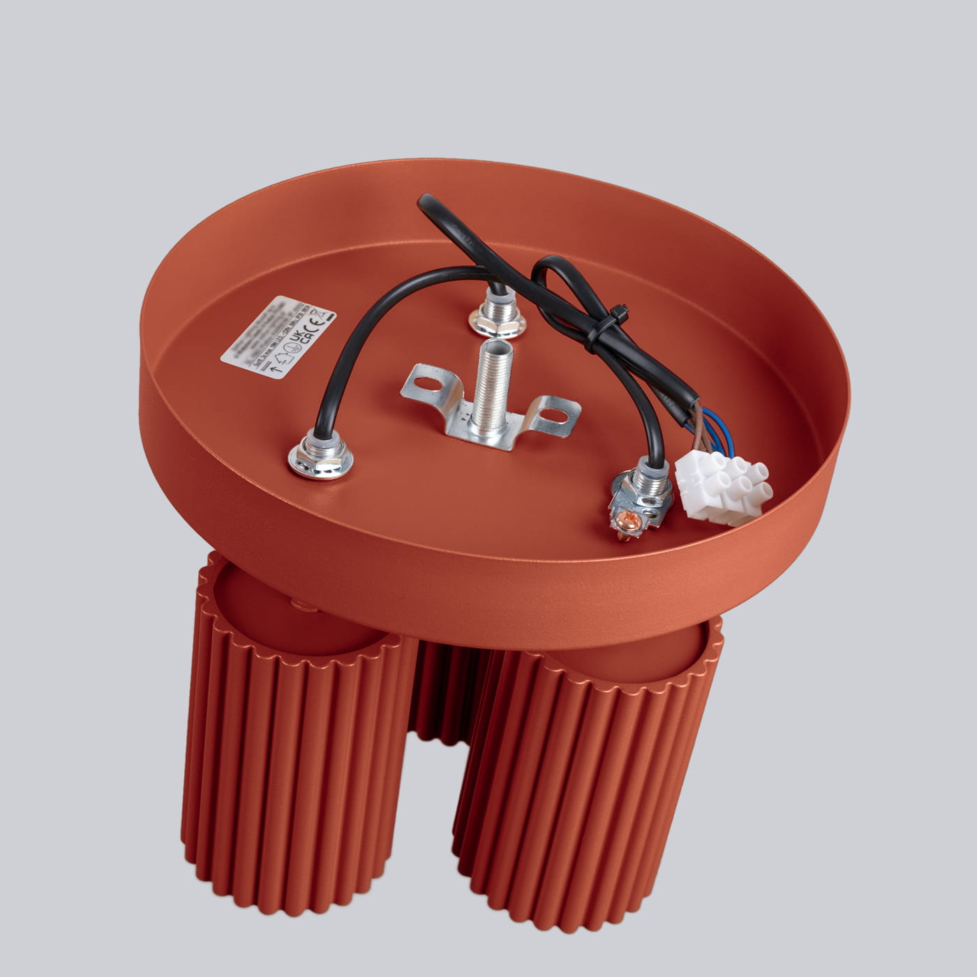 Lampa sufitowa Karbon w kolorze ochra czerwona, z trzema gniazdami GU10, z metalową podstawą i dwoma cylindrycznymi, żłobionymi elementami. Widok z góry, ukazujący przewody elektryczne oraz mocowanie.