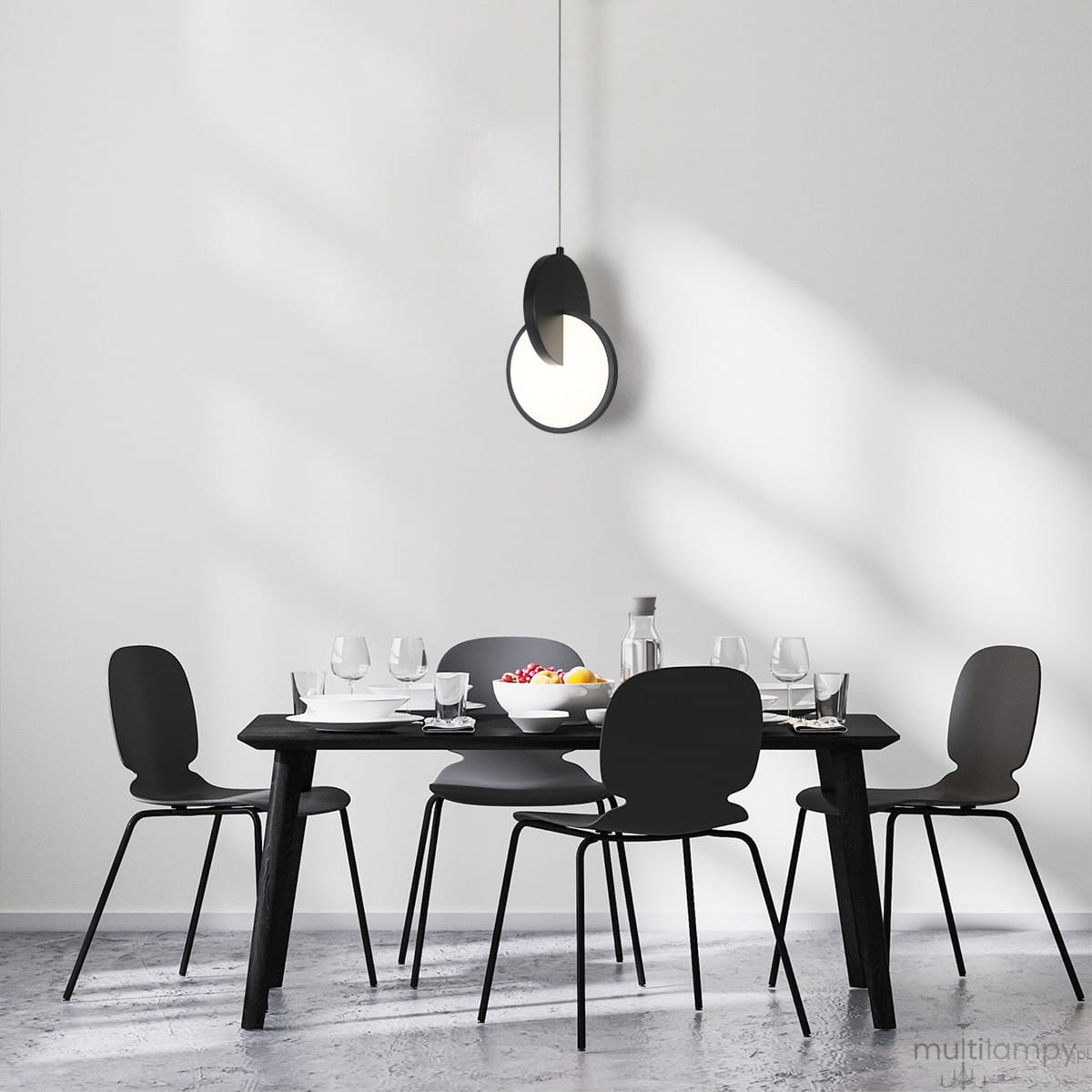 Czarna lampa wisząca Circlo z jedną żarówką LED 8W, umieszczona nad stołem w minimalistycznej jadalni. Lampa ma okrągły kształt z półprzezroczystym elementem, wisząca na cienkim kablu, w otoczeniu czarnych krzeseł i stołu.
