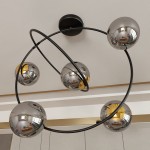 Lampa sufitowa Stardom w kolorze czarnym i grafitowym, z pięcioma kulistymi kloszami w odcieniach chromu i złota. Ujęcie z dołu, ukazujące elegancki, nowoczesny design z okrągłym mocowaniem.