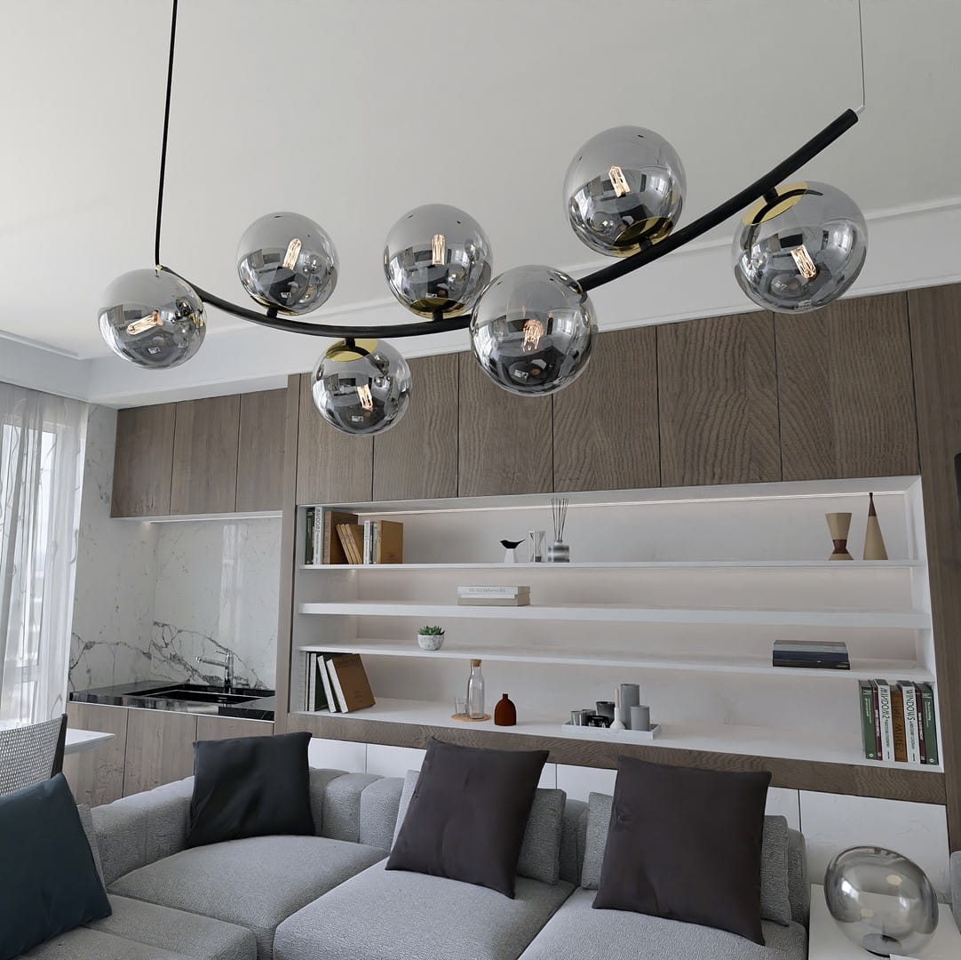Lampa wisząca Ritz z siedmioma oprawami na żarówki E14 w kolorze czarnym i grafitowym. Ułożona na zakrzywionej, metalowej podstawie. Szklane klosze w kształcie kul odbijają światło, nadając nowoczesny charakter wnętrzu.