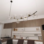 Lampa wisząca Ritz z siedmioma kloszami E14 w czarnej i transparentnej kolorystyce. Ułożona na lekkim łuku, z przezroczystymi szklanymi kulami, umieszczona w nowoczesnym wnętrzu z drewnianymi meblami.