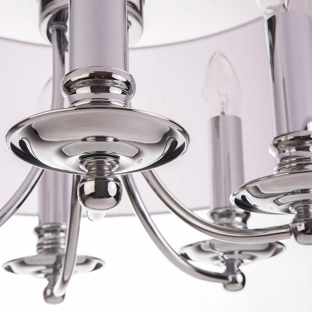 Lampa wisząca Abu Dhabi 5-punktowa w chromie, z widocznymi eleganckimi ramionami i szklanymi kloszami. Ujęcie z bliska pokazuje detal metalowych elementów, połyskujących na jasnym tle.