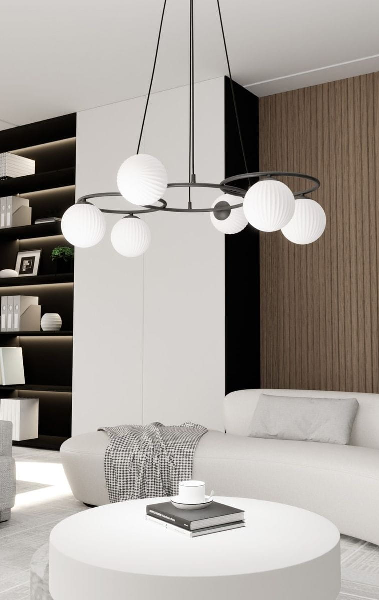 Lampa wisząca Libra 6xE14 w kolorze czarnym z opalowymi kulami. Zawieszona na cienkich linkach, z okrągłym metalowym stelażem. Widoczne w tle nowoczesne wnętrze z jasnymi i ciemnymi elementami mebli.