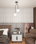 Lampa sufitowa Atria 2xE14 w kolorze czarnym z opalowymi kloszami, zawieszona na podwójnym ramieniu. Stylowy design, idealna do nowoczesnych wnętrz, umieszczona w pokoju z jasnymi ścianami i eleganckim meblem obok.