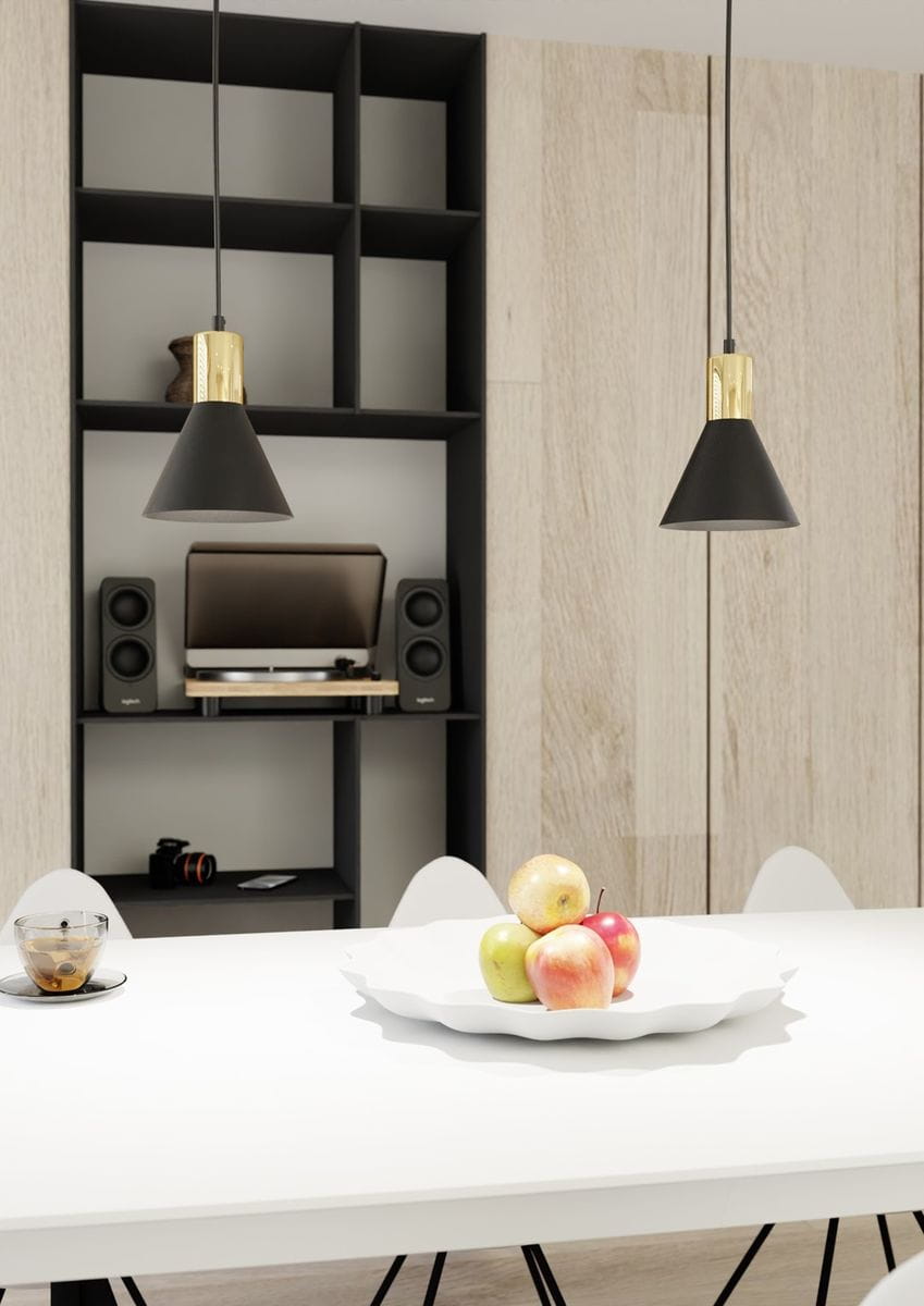 Lampa wisząca Rosa 1xE27 w kolorze czarnym z złotym detalem, o stożkowatej formie, zawieszona nad białym stołem. W tle widoczne półki w kolorze czarnym oraz sprzęt audio. Na stole biały talerz z jabłkami.
