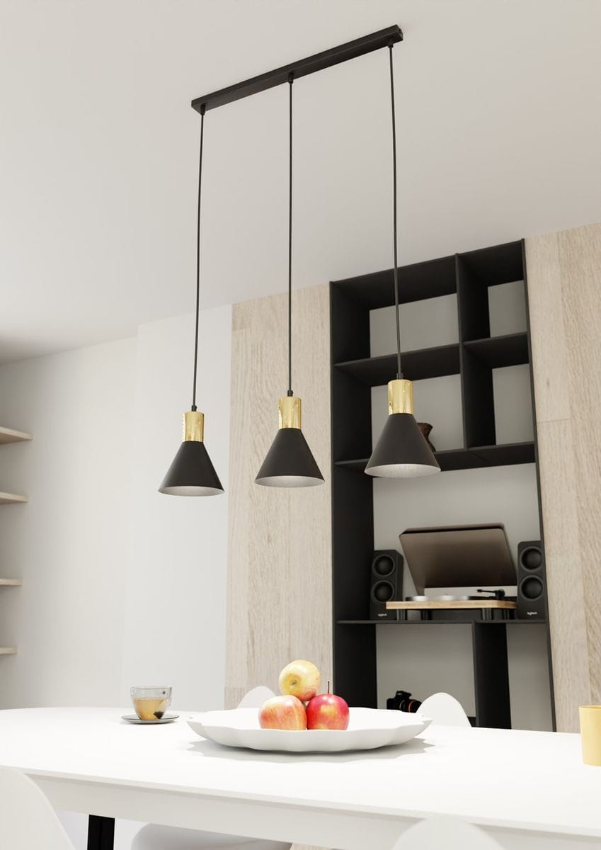 Lampa wisząca Rosa w kolorze czarnym i złotym, z trzema kloszami w kształcie stożka zawieszonymi na czarnych przewodach. Umieszczona nad białym stołem, w tle półki z drewnianymi elementami oraz sprzętem audio.