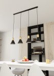 Lampa wisząca Rosa z czterema kloszami w kształcie stożka, w kolorze czarnym z złotymi detalami, zawieszona na cienkich linkach. Widoczna w nowoczesnej aranżacji kuchennej nad białym stołem, z talerzem owoców i filiżanką obok.
