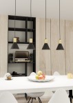 Lampa wisząca Rosa 4xE27 w kolorze czarnym z złotymi elementami, w kształcie stożków, zawieszona na cienkich kablach. Zbliżenie na stół z białym obrusem, na którym znajduje się talerz z owocami oraz filiżanka. Tło w jasnych odcieniach drewna.