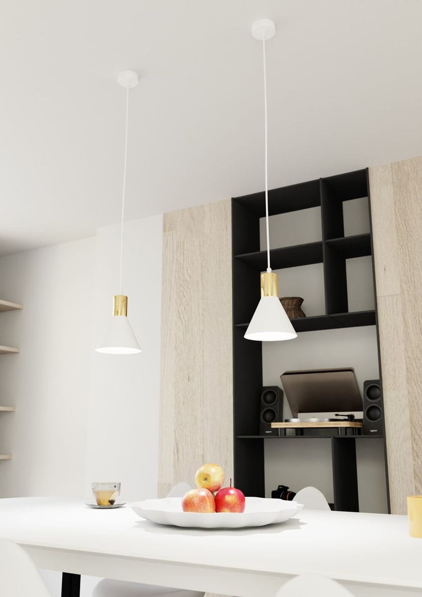 Lampa wisząca Rosa z białym kloszem i złotym wykończeniem, zawieszona na białym przewodzie. Widoczna w nowoczesnej aranżacji kuchennej, w towarzystwie białego stołu i owoców w misie. Tło jasne, z drewnianymi panelami i czarnymi półkami.