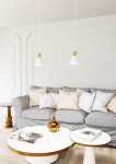 Lampa wisząca Rosa 1xE27 w kolorze białym z złotymi akcentami, o stożkowym kształcie, zawieszona na długich linkach, w aranżacji z szarym sofą i stolikami kawowymi. Tło jasne, minimalistyczne, podkreślające elegancję lampy.