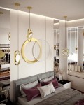 Lampa wisząca Spinner 19, złota, z jedną żarówką LED 7W, zawieszona nad łóżkiem w stylowej sypialni. Charakterystyczny kształt w formie okręgów i elips, z dekoracyjnymi elementami, w nowoczesnym wnętrzu z neutralnym tłem.
