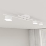Fragment lampy sufitowej 3xGX53 w kolorze białym, z trzema okrągłymi źródłami światła zamocowanymi na prostokątnej ramie. Lampa montowana na suficie, z minimalistycznym designem, umieszczona w jasnym wnętrzu.