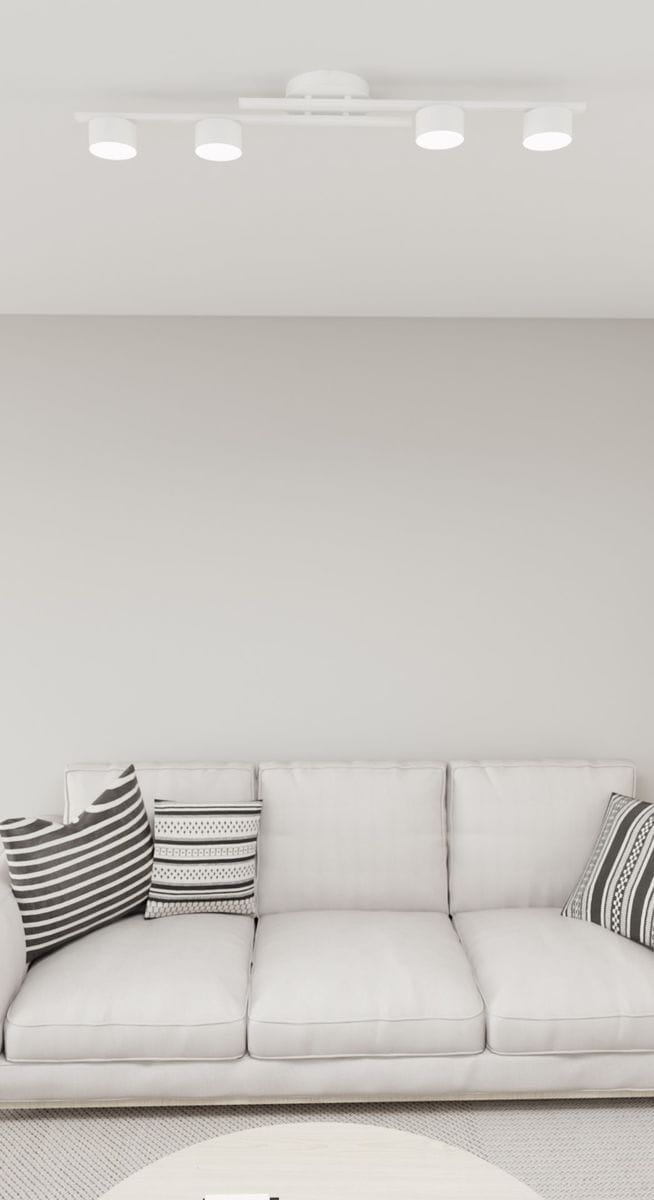 Biała lampa sufitowa 4xGX53 z okrągłymi kloszami, zamontowana na suficie. Widoczne trzy źródła światła, prosty, minimalistyczny design. Otoczenie to jasny pokój z szarymi ścianami i jasną kanapą z poduszkami w paski.
