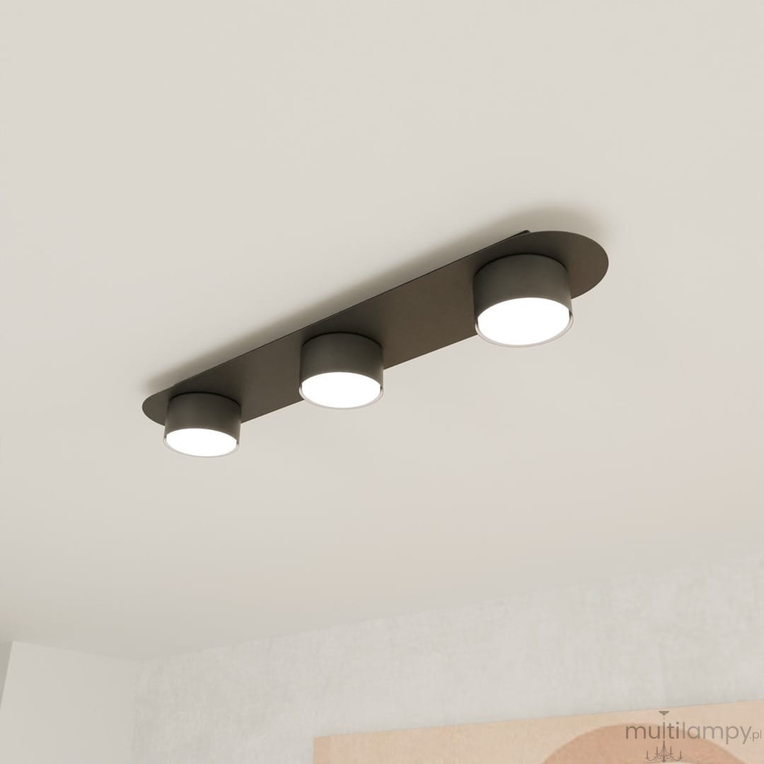 Lampa sufitowa Diaz 3xGX53 w kolorze czarnym, z trzema okrągłymi źródłami światła, zamontowana na prostokątnej podstawie. Ujęcie z dołu, ukazujące minimalistyczny design i równomierne rozmieszczenie lamp. Tło jasne, neutralne.