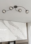 Czarna lampa sufitowa Vibra z czterema kloszami E14 w kształcie okrągłych, szklanych kul. Klosze mają prążkowaną fakturę i są zawieszone na delikatnych, zakrzywionych ramionach. Lampa zamontowana na białym suficie, w tle widoczna jasna, marmurowa ściana.