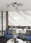 Lampa sufitowa Vibra 6xE14 w kolorze czarnym i grafitowym. Osiem żarówek w przezroczystych kloszach, umieszczone na giętkich ramionach. Zawieszona w nowoczesnym wnętrzu z niebieską kanapą i dekoracjami.