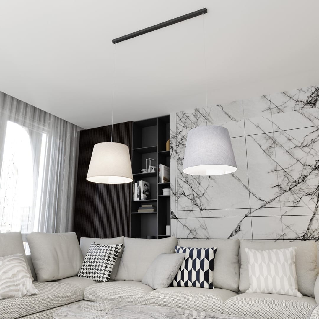 Lampa wisząca Epoca z dwoma kloszami w kolorze szarym i jasnym, zawieszona na czarnej listwie. Klosze mają cylindryczny kształt, a w tle widoczne są elementy nowoczesnego wnętrza z szaro-białą ścianą i sofą z poduszkami.