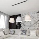 Lampa wisząca Epoca z trzema kloszami w różnych odcieniach: czarnym, szarym i białym. Klosze o okrągłym kształcie zawieszone na czarnym stelażu. Umieszczona w nowoczesnym wnętrzu z jasną sofą i wzorzystymi poduszkami.