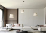 Lampa wisząca Ascot 3xE27 w kolorze czarnym i beżowym, z trzema kloszami w kształcie stożka, zawieszona na cienkich linkach. Produkt znajduje się w nowoczesnym wnętrzu z jasnymi meblami i drewnianymi akcentami.