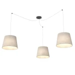 Lampa wisząca Ascot z trzema kloszami w kolorze beżowym, zawieszona na cienkich przewodach, z czarnym mocowaniem sufitowym. Klosze mają stożkowy kształt i emitują ciepłe światło, idealna do nowoczesnych wnętrz.