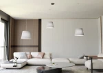 Lampa wisząca Ascot 3xE27 w kolorze czarnym i szarym, z kloszami w kształcie stożka, zawieszona na cienkich linkach. Widoczne trzy lampy w nowoczesnym wnętrzu z jasną sofą i okrągłym stolikiem. Tło w neutralnych odcieniach, minimalistyczne.