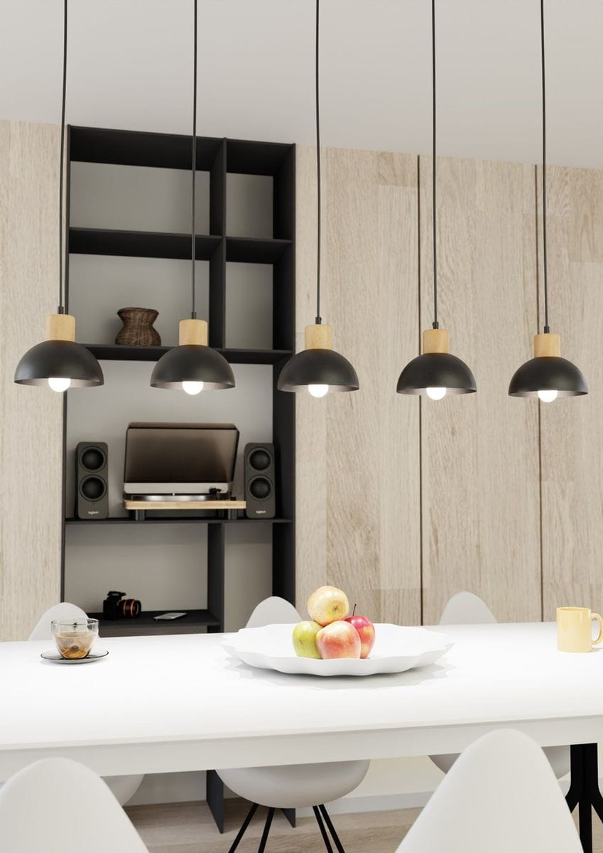 Lampa wisząca Seco, pięć kloszy w czarnym kolorze z drewnianymi elementami, zawieszona na cienkich przewodach. Klosze mają zaokrąglony kształt, a całość umieszczona nad białym stołem, z owocami na talerzu i nowoczesnym tłem.