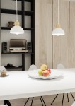 Lampa wisząca Seco 1xE27 w kolorze białym z jasnym drewnem. Kształt okrągły, zawieszona na białym kablu. W tle widoczna aranżacja wnętrza z białym stołem, misą z owocami oraz sprzętem audio. Tło w odcieniach szarości i drewna.