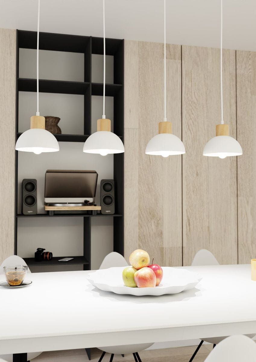 Lampa wisząca Seco 4xE27 w białym kolorze z jasnym drewnem, zawieszona na białych linkach. Cztery klosze w kształcie półkuli umieszczone równolegle, nad białym stołem z owocami. Tło z jasnymi drewnianymi panelami, czarna półka z elektroniką.