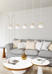 Lampa wisząca Seco z pięcioma białymi kloszami w jasnym drewnie, zawieszona na białych kablach. Klosze mają prosty, okrągły kształt. W tle widoczna szara sofa z poduszkami oraz stolik kawowy z okrągłym blatem.