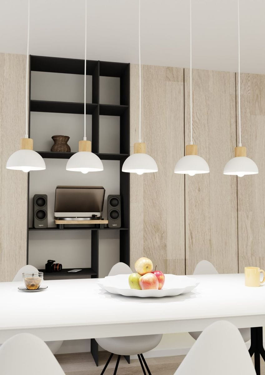 Lampa wisząca Seco z pięcioma kloszami E27 w kolorze białym i jasnym drewnie. Zawieszona na długich, białych przewodach, idealna do nowoczesnych wnętrz. Widoczna w aranżacji nad stołem, w otoczeniu owoców i sprzętu audio.