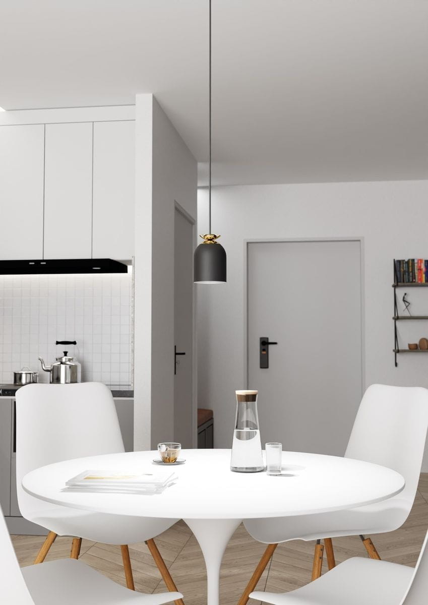 Lampa wisząca Target z pojedynczym źródłem E27 w kolorze czarnym z złotym detalem, zawieszona na cienkim przewodzie. Umieszczona nad okrągłym, białym stołem w nowoczesnej kuchni, otoczona białymi krzesłami z drewnianymi nogami.