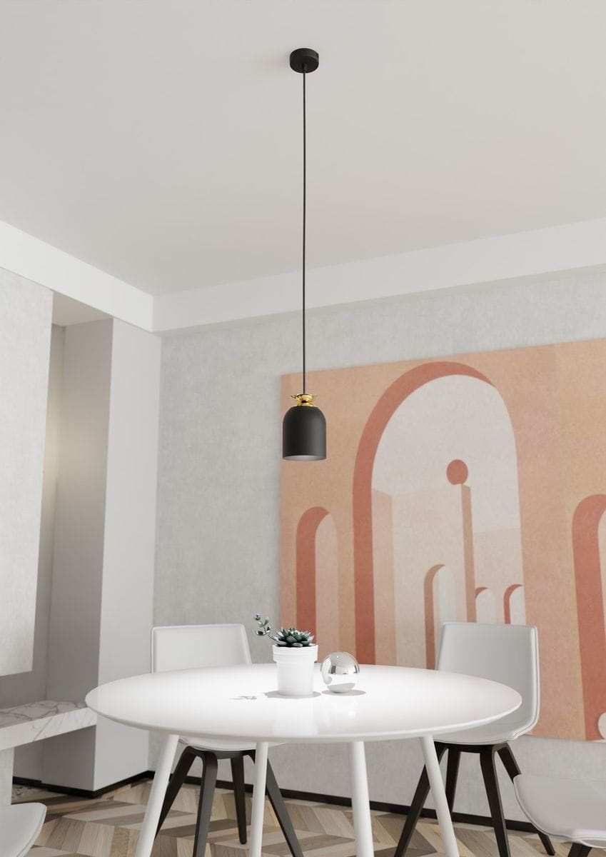 Lampa wisząca Target 1xE27 w kolorze czarnym z złotymi detalami, zawieszona na długim przewodzie. Widok z dołu na lampę, umiejscowioną nad okrągłym, białym stołem w minimalistycznym wnętrzu. Tło z delikatnym muralem w odcieniach różu i beżu.