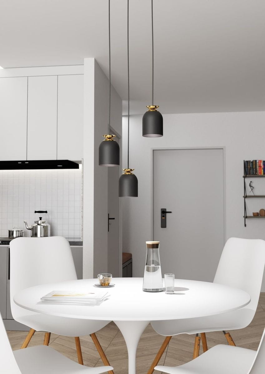Lampa wisząca Target 3xE27 w kolorze czarnym i złotym, z trzema cylindrycznymi kloszami, zawieszona na długich przewodach. Zdjęcie przedstawia lampa nad okrągłym białym stołem w nowoczesnej kuchni, z jasnym tłem i minimalistycznym wystrojem.