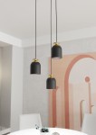 Lampa wisząca Target z trzema kloszami w kolorze czarnym i złotymi detalami. Ujęcie z góry pokazuje klosze o zaokrąglonym kształcie na długich przewodach, zawieszone nad okrągłym stołem w jasnym wnętrzu z dekoracyjną ścianą w tle.