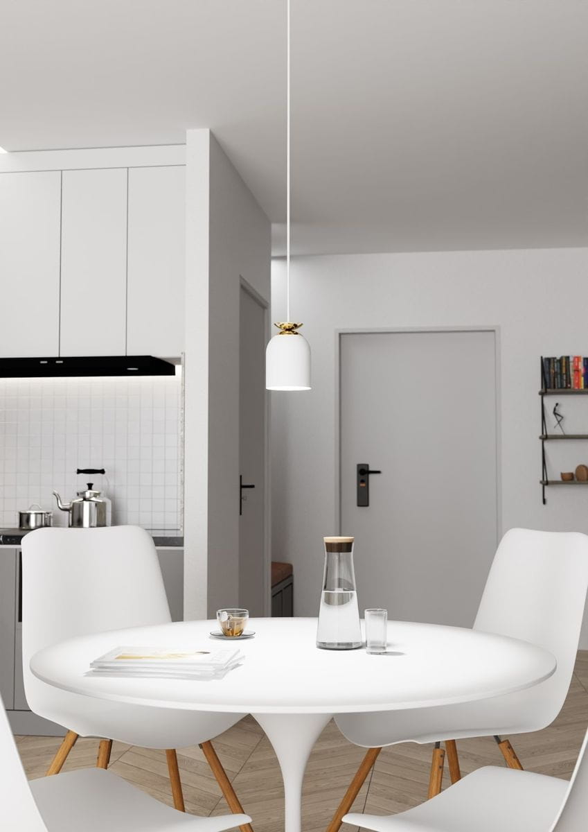 Lampa wisząca Target 1xE27 w kolorze białym z złotym detalem, zawieszona na cienkim przewodzie, umieszczona nad okrągłym białym stołem. W tle widoczne białe meble kuchenne i drzwi do pomieszczenia.