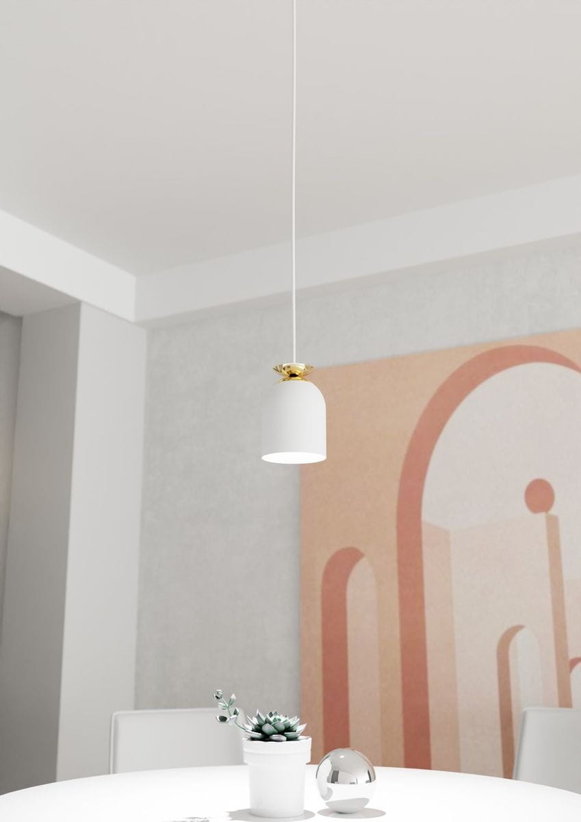 Lampa wisząca Target z białym kloszem i złotym detalem montażowym, zawieszona na cienkim przewodzie. Klosz ma kształt stożka z otwartym dnem. Tło prostego wnętrza z subtelnymi wzorami w odcieniach różu.