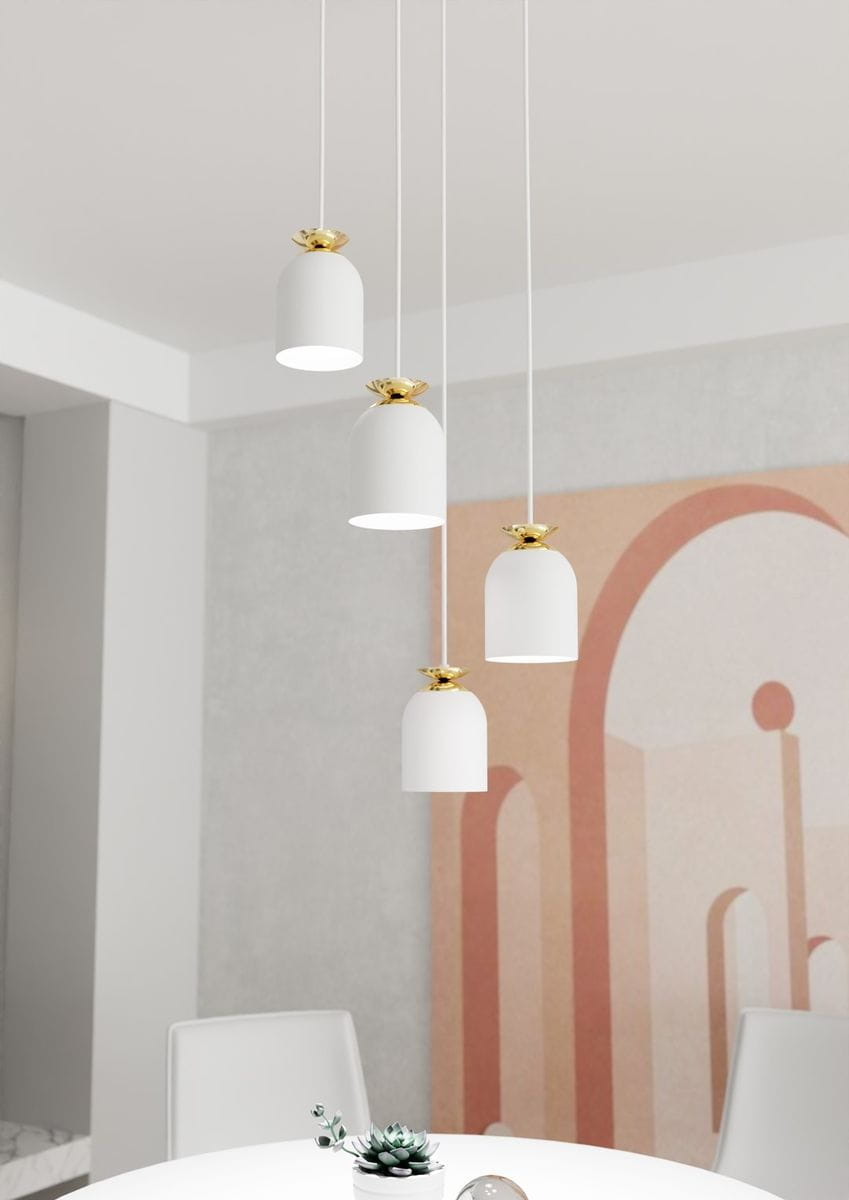 Lampa wisząca Target 4xE27 w kolorze białym z złotymi detalami. Cztery cylindryczne klosze zawieszone na długich przewodach, umieszczone nad okrągłym stołem w nowoczesnym wnętrzu, z tłem w jasnych odcieniach.