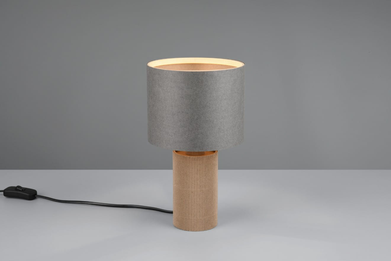 Lampa stołowa Canio z szarym abażurem i naturalnym, koralikowym stelażem. Ujęcie frontalne, lampa stoi na jednolitym tle. Widoczny kabel z przełącznikiem. Abażur ma okrągły kształt, a stelaż cylindryczny z wyraźną teksturą.
