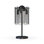 Lampa stołowa Nira z trzema gniazdami E14, w kolorze czarnym i chromowanym. Posiada przezroczyste klosze w kształcie fal, umieszczone na metalowej podstawie. Produkt stoi na płaskiej, okrągłej podstawie.