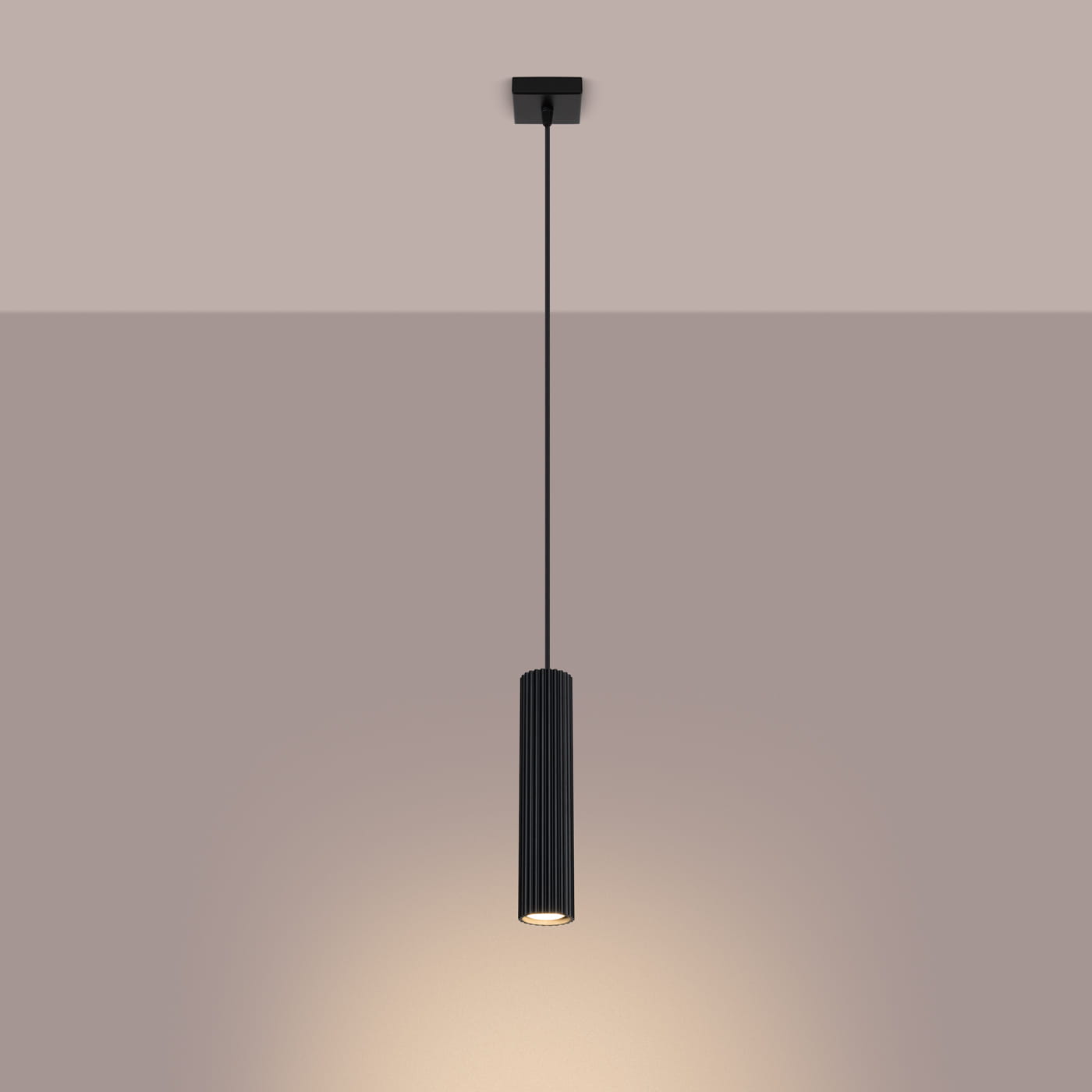 Lampa wisząca Karbon 1 w kolorze czarnym, z pojedynczym źródłem światła GU10. Charakteryzuje się cylindrycznym kształtem z poziomymi żłobieniami. Zawieszona na cienkim przewodzie, emitująca światło w dół, na jednolitym tle.