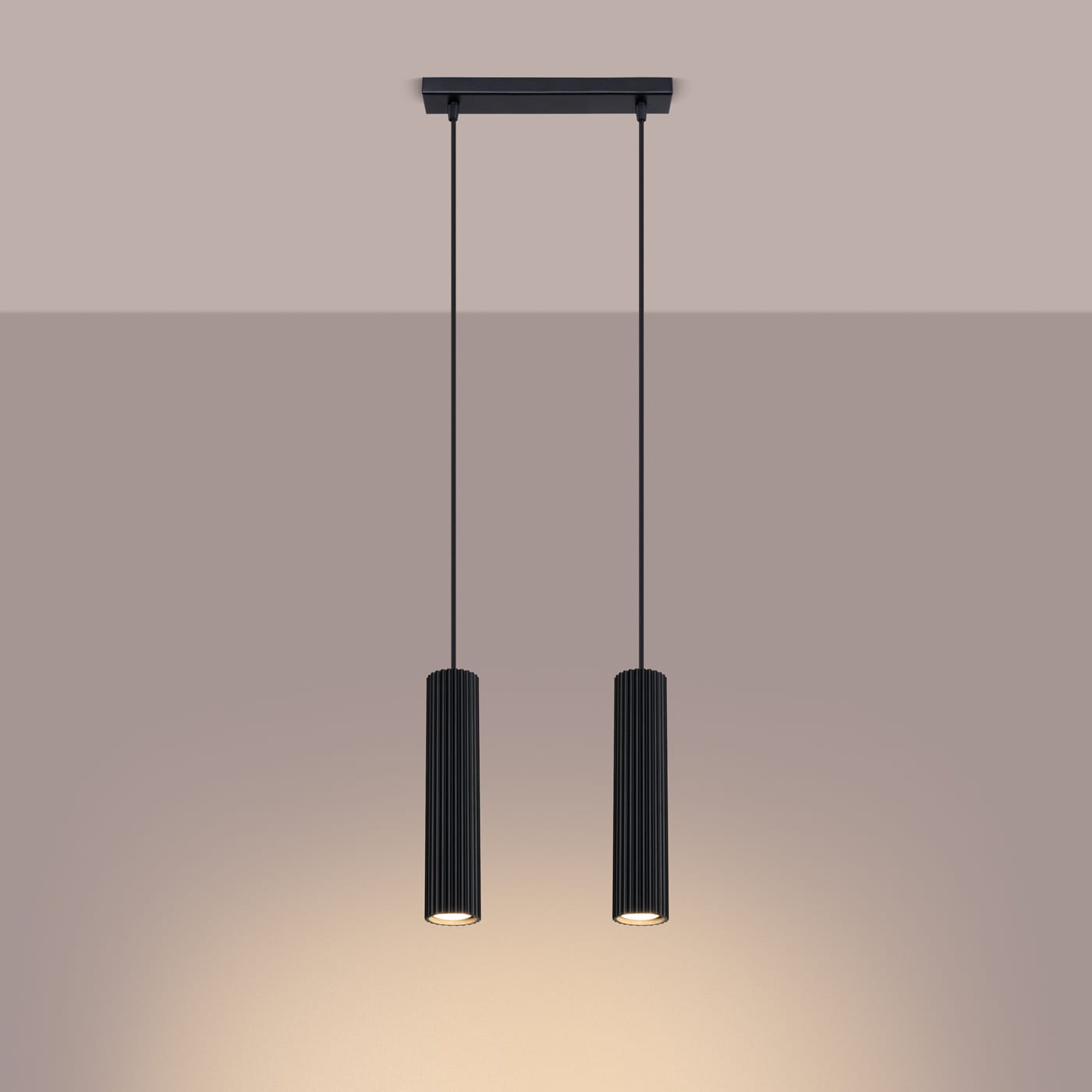 Lampa wisząca Karbon 2 o czarnym kolorze z dwiema cylindrycznymi oprawami, zawieszona na dwóch cienkich linkach. Klasyczny design z rowkowaną fakturą, przeznaczona do żarówek GU10. Ujęcie frontalne na jednolitym tle.
