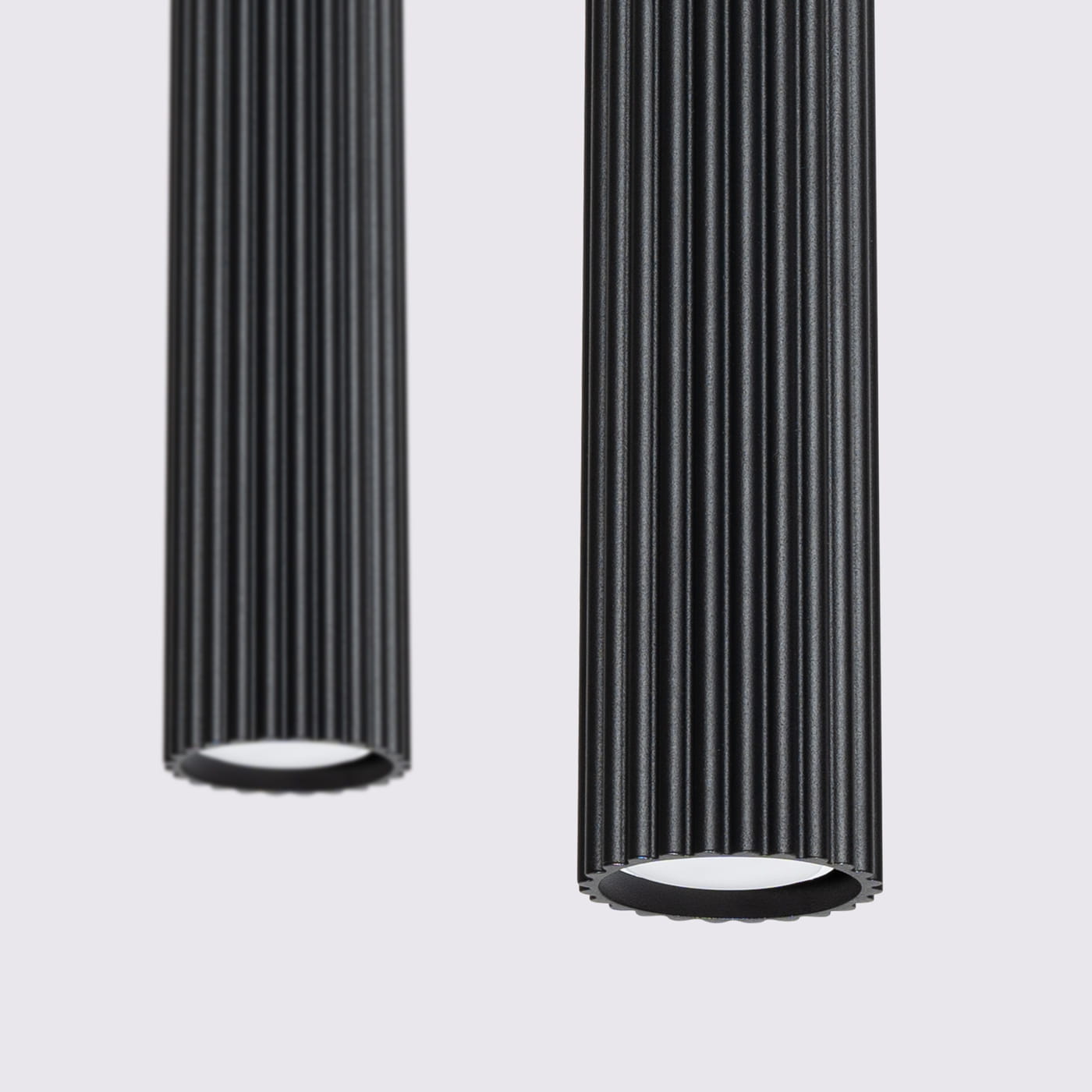 Lampa wisząca Karbon 2 w kolorze czarnym, z dwoma cylindrycznymi kloszami o teksturowanej powierzchni. Klosze z oprawkami GU10, zawieszone w dół, prezentujące minimalistyczny design. Tło jasne, podkreślające elegancję lampy.