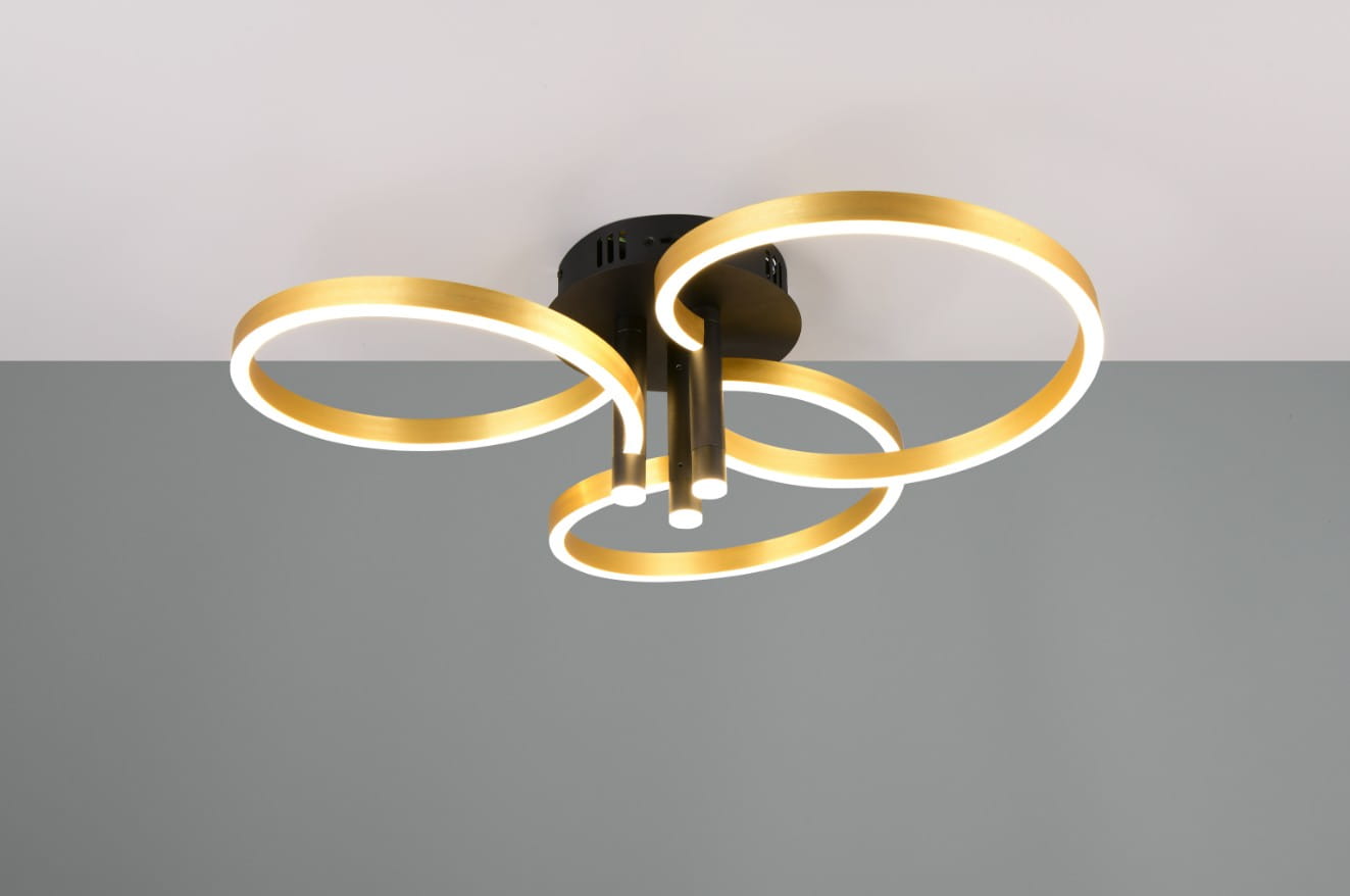 Lampa sufitowa Caruso z jednym źródłem światła LED, o mocy 43W. Posiada trzy złote okręgi z białym podświetleniem, zamontowana na czarnej podstawie. Ujęcie z dołu, ukazujące detale konstrukcji oraz kształt lampy.