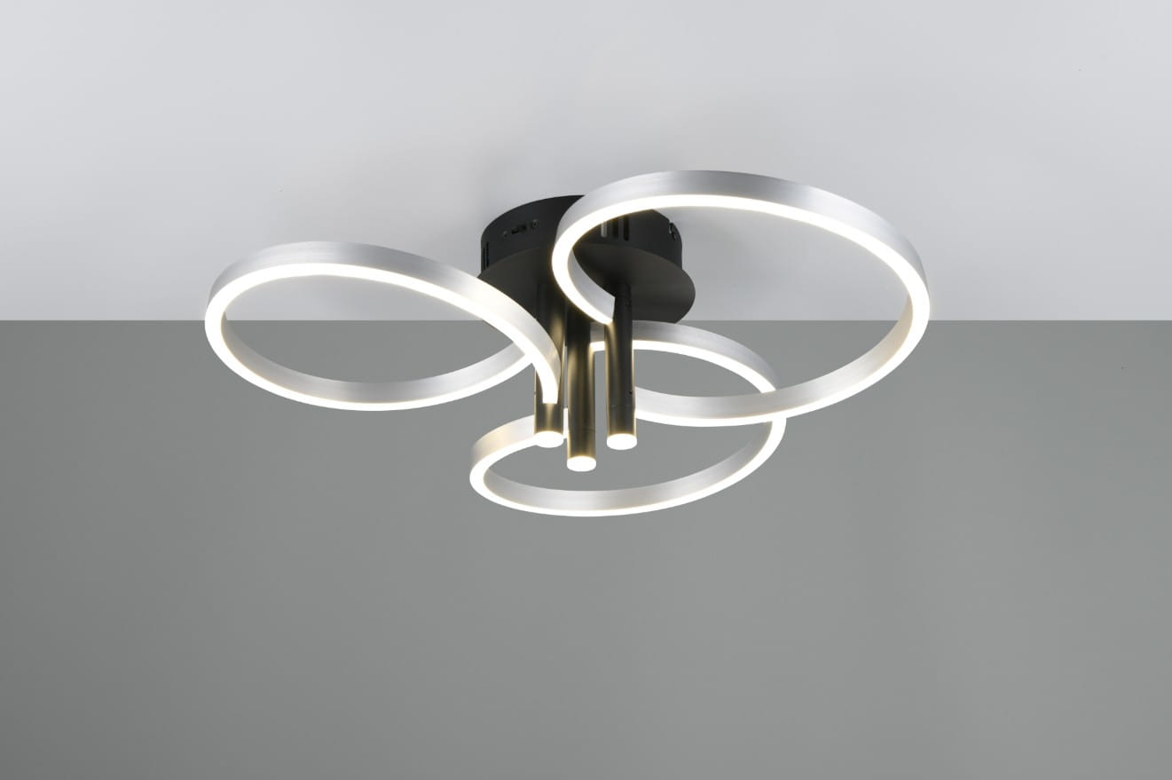 Lampa sufitowa Caruso w kolorze czarnym i aluminium, z trzema okrągłymi pierścieniami LED. Zawieszona na suficie, z widocznymi źródłami światła. Prosta forma z nowoczesnym designem, na jednolitym szarym tle.