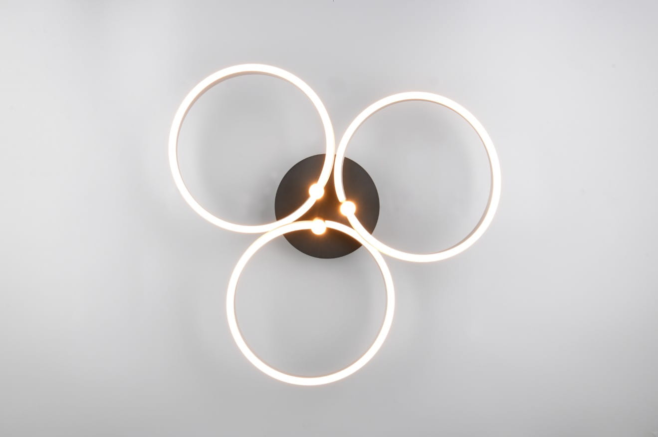Lampa sufitowa Caruso w kolorze czarnym z aluminium, z trzema okrągłymi pierścieniami emitującymi światło LED. Ujęcie z góry, ukazujące złącze centralne oraz lśniące krawędzie pierścieni. Prosta, nowoczesna forma idealna do wnętrz.