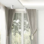 Biała lampa sufitowa Turyn IP44 w kształcie tuby z jedną oprawą GU10, zamontowana na suficie. W tle widoczne zasłony i okno, co nadaje kontekst aranżacji wnętrza. Lampa emituje światło, oświetlając przestrzeń.