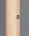 Lampa podłogowa Celeste z czarną, przydymioną kloszem i drewnianą nogą w jasnym kolorze. Widoczny detal to metalowy przycisk na nogi lampy. Produkt w pozycji stojącej, na jednolitym tle szarym.